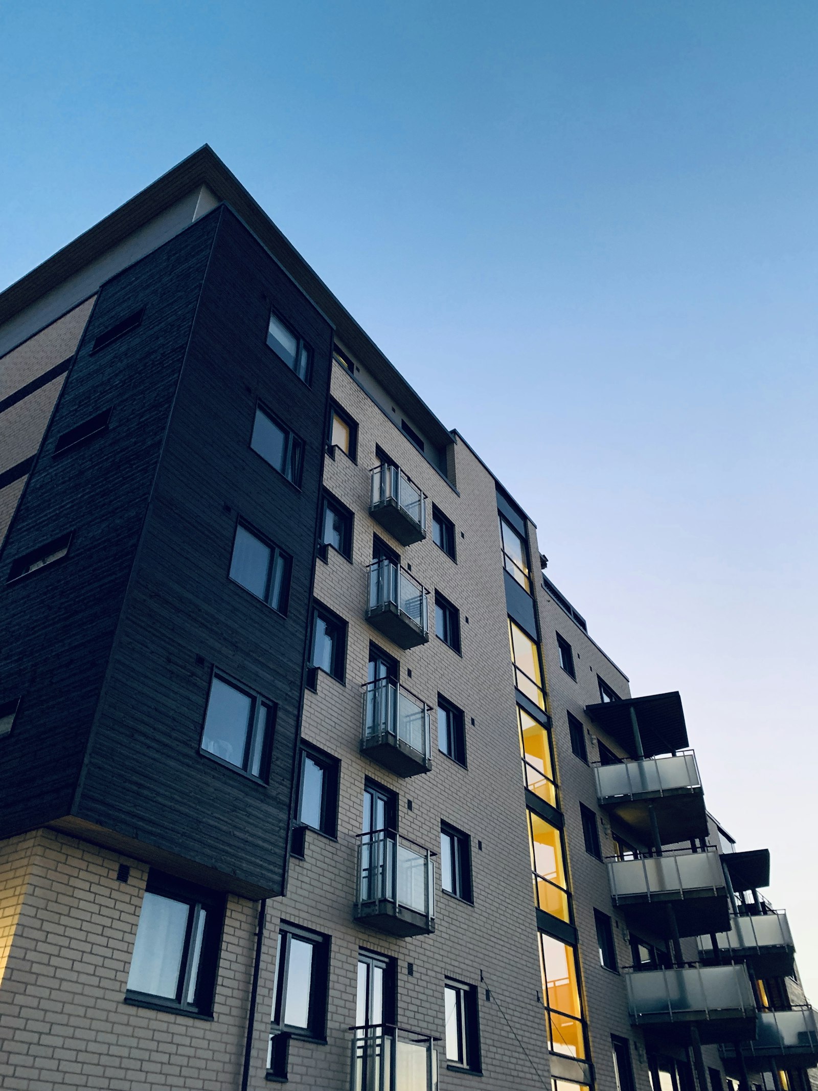 Coastal apartment building framed by palm trees at dusk